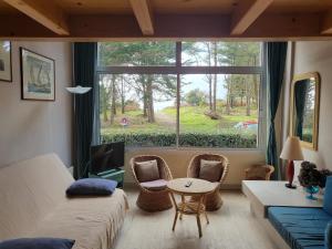 Habitación con cama, mesa y ventana en Plage des Dunes - Grand Studio ouvert avec 1 mezzanine et 1 alcôve, en Fouesnant