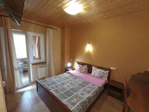 Schlafzimmer mit einem Bett mit rosa Bettwäsche und einem Fenster in der Unterkunft Villa Leontiya in Schidnyzja