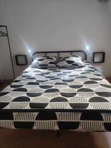 ein schwarz-weißes Bett in einem Zimmer in der Unterkunft Bienvenue chez Coco in Dunkerque