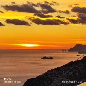 a sunset over the ocean with the sun setting at Casa Barbara in Amalfi