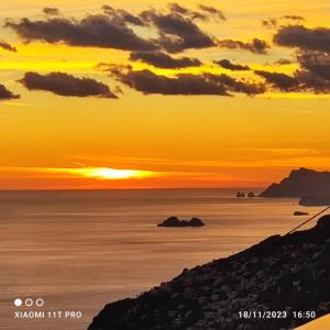 una puesta de sol sobre el océano con la puesta de sol en Casa Barbara, en Amalfi