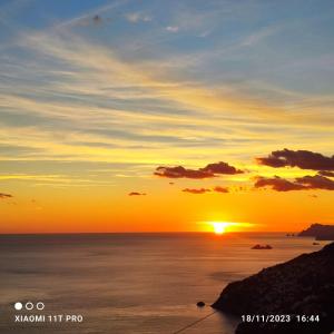 una puesta de sol sobre el océano con la puesta de sol en Casa Barbara, en Amalfi