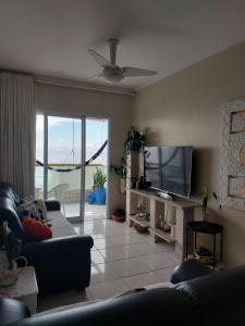 sala de estar con sofá y TV de pantalla plana en Tupi - Praia Grande, en Praia Grande