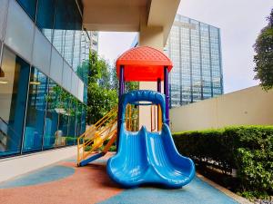 a playground with a slide in front of a building at Luxury 2BR with Balcony Suite 8 - City View in Manila
