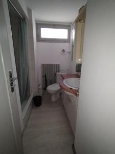 ein Bad mit einem WC, einem Waschbecken und einem Fenster in der Unterkunft Chambre 3 lits simples cuisine commune in Saint-Pierre-du-Mont