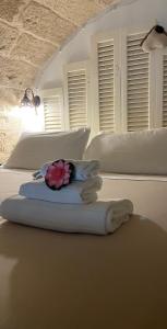 ポリニャーノ・ア・マーレにあるB&B Casa Fioreのベッドルーム1室(白い枕と花の上にベッド2台付)
