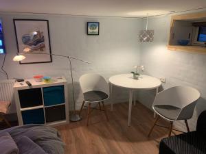 a living room with a table and chairs and a bed at Central by lejlighed in Nykøbing Falster