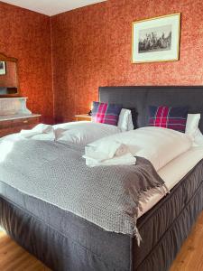 ein großes Bett in einem Schlafzimmer mit einer roten Wand in der Unterkunft DU GLACIER Boutique & Traditions Hotel in Fiesch