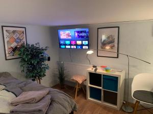 a bedroom with a bed and a tv on the wall at Central by lejlighed in Nykøbing Falster