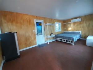 a bedroom with a bed in a room with wooden walls at เคียงคลองโฮมสเตย์(สวนโควินท์) in Ban Bang Pa Nok
