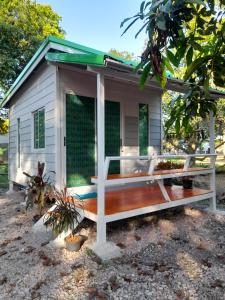 a tiny house with a porch and a deck at เคียงคลองโฮมสเตย์(สวนโควินท์) in Ban Bang Pa Nok