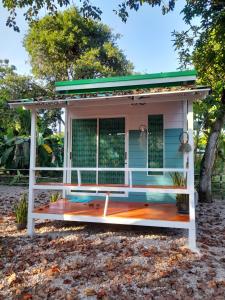 a tiny house with a porch and a green roof at เคียงคลองโฮมสเตย์(สวนโควินท์) 