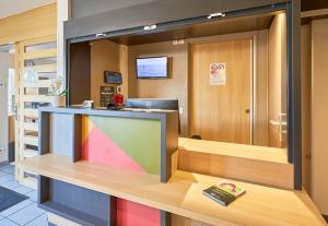 an office with a colorful counter with a book on a desk at B&B HOTEL Honfleur in Honfleur