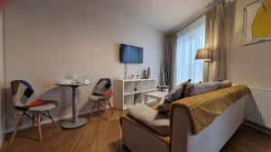 Apartament Wieliczka في فياليتشكا: غرفة معيشة مع أريكة وطاولة