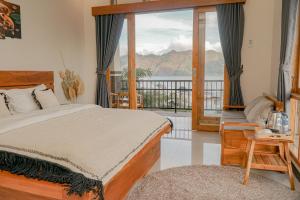 a bedroom with a bed and a balcony with a view at Casa Lago Batur in Kubupenlokan