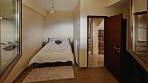 um pequeno quarto com uma cama e um closet em Τα πέτρινα στο Σκεπαστό em Kalavrita