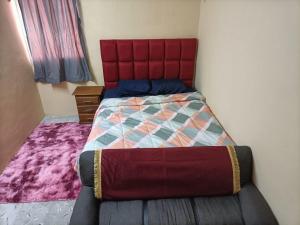 uma cama com uma cabeceira vermelha num quarto em La Preciosa Casa Andaluza em Mérida