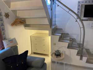 ein Wohnzimmer mit einem Sofa und einer Treppe in der Unterkunft Huus Lüttenblick Single Wohnung Kajüte in Südstrand