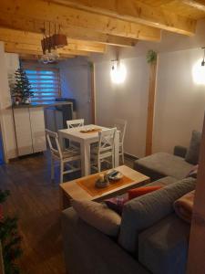 una sala de estar con una mesa y un sofá en Holiday Homes Biser Lopatnice, en Lopatnica