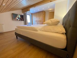 ein Schlafzimmer mit einem großen Bett mit weißer Bettwäsche und Kissen in der Unterkunft das Landblick in Sillian