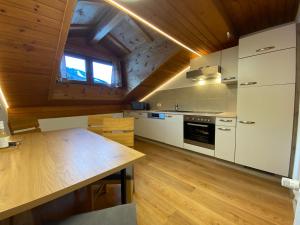 a kitchen with white cabinets and a wooden floor at das Landblick in Sillian