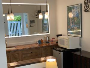 a kitchen with a counter with a microwave and a mirror at Alexander Palms Court - No Hidden Resort Fees! in Key West