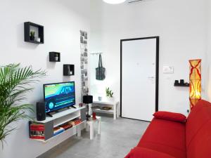 un soggiorno con divano rosso e TV di La Casa di Cri a Bologna