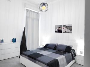 - une chambre blanche avec un lit noir et blanc dans l'établissement La Casa di Cri, à Bologne