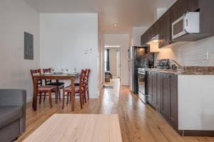 a kitchen and living room with a table and chairs at 5-STAR Prime Location - Bright Condo in Montréal