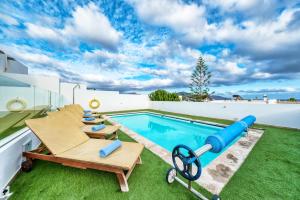 a backyard pool with a inflatable pool noodle next to a pool at Casa Iria in Playa Blanca