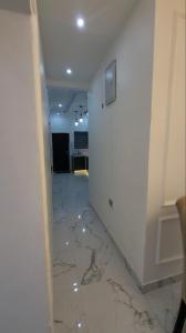 einen Flur mit Marmorböden und einer weißen Wand in der Unterkunft 3 bed apartments at awoyaya, ibeju lekki. Lagos. in Awoyaya