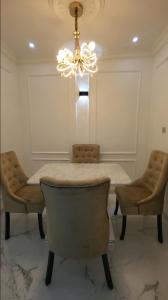 a dining room with a table and chairs and a chandelier at 3 bed apartments at awoyaya, ibeju lekki. Lagos. in Awoyaya