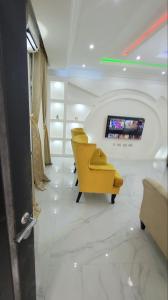 a waiting room with yellow chairs and a flat screen tv at 3 bed apartments at awoyaya, ibeju lekki. Lagos. in Awoyaya