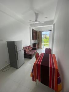 cocina y sala de estar con mesa y nevera en Apartment near Colombo Airport en Katunayaka