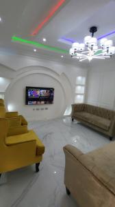 ein Wohnzimmer mit einem Sofa und einem TV in der Unterkunft 3 bed apartments at awoyaya, ibeju lekki. Lagos. in Awoyaya