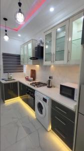 a kitchen with a stove and a washing machine at 3 bed apartments at awoyaya, ibeju lekki. Lagos. in Awoyaya