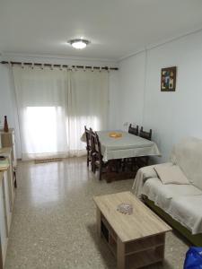uma sala de estar com uma mesa e um sofá em Apartamento tradicional em Canet d'En Berenguer