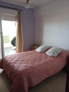 um quarto com uma cama com um edredão vermelho em Apartamento tradicional em Canet d'En Berenguer