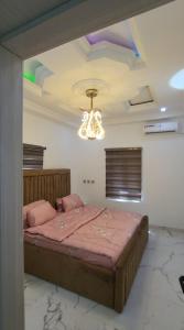 Schlafzimmer mit einem Bett und einem Kronleuchter in der Unterkunft 3 bed apartments at awoyaya, ibeju lekki. Lagos. in Awoyaya