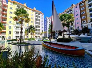 a small boat with a sail in a river in a city at Luxury stay Seven cote Azur in Na Jomtien