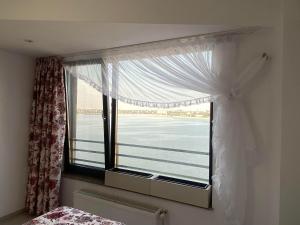 a bedroom window with a view of the ocean at Lake House - Bucuresti in Bucharest