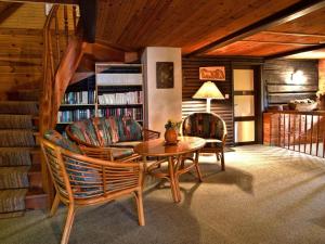 a living room with a table and chairs and a book shelf at Haus Grafhube in Afritz-Verditz in Innere Einöde
