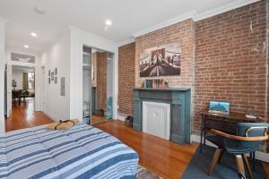 - une chambre avec un mur en briques, un lit et une cheminée dans l'établissement Large Home Near NYC In Hoboken Sleeps 6, à Hoboken