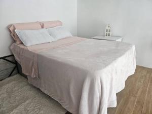 een slaapkamer met een groot bed en een witte deken bij Acogedor, inolvidable in Montevideo