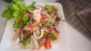 a salad with shrimp and vegetables on a white plate at Riverhill khaoyai Camping in Pong Talong