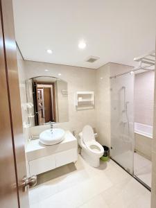 La salle de bains est pourvue de toilettes, d'un lavabo et d'une douche. dans l'établissement City Center 4BR Apartment, à Hanoï