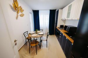 Modern Studio في Ipoteşti: مطبخ صغير مع طاولة وكراسي في الغرفة