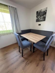 uma sala de jantar com uma mesa de madeira e cadeiras azuis em Frühstückspension Alpenrose Bed & Breakfast em Iselsberg