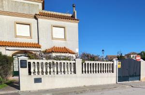 チピオナにあるLa Pavona 11 - 1ª línea de Playa Chipionaの家の前の白い柵