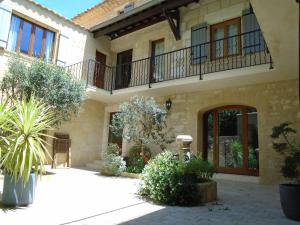 una casa con balcone e cortile di Jim cosy & spa a Saint-Hilaire-dʼOzilhan